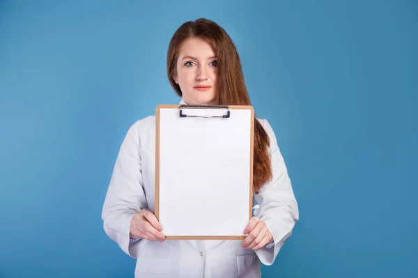 Vrouwelijke Dokter Toont Blanco Klembord Blauwe Studio Achtergrond Medisch Concept — Stockfoto