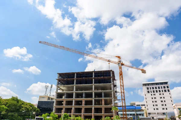 Grúa elevando contenedor mezclador de concreto contra el cielo azul — Foto de Stock