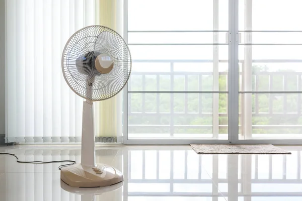 Ventilatoren vor den Vorhängen im Raum platziert. Stockbild