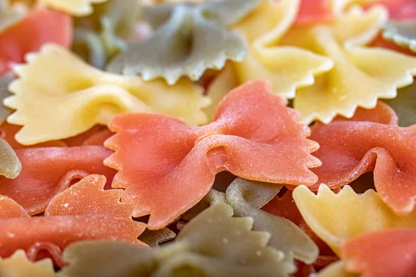 Разноцветное Итальянское Сырье Pasta Farfalle Разливается Больших Количествах Фон Закрывай — стоковое фото