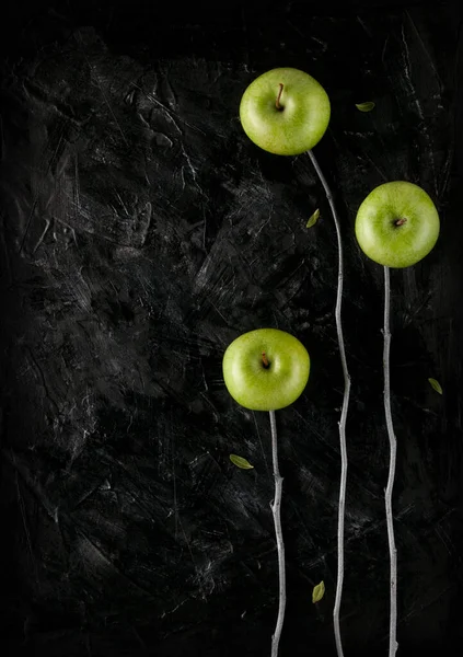 Siyah arkaplanda dikey üç elma ağacı