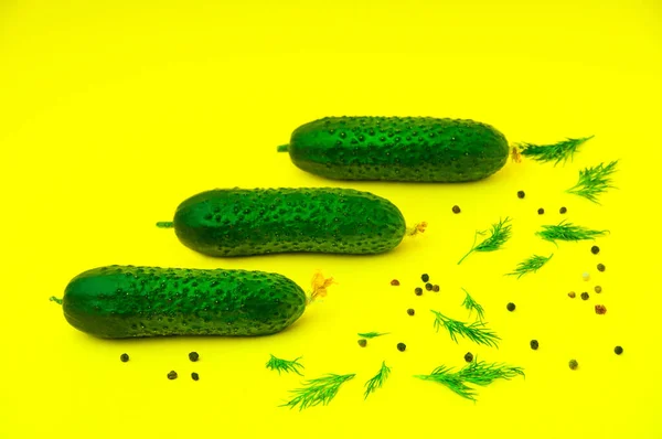 Mutfaktaki sarı arka planda üç salatalık, biber ve yeşillik.