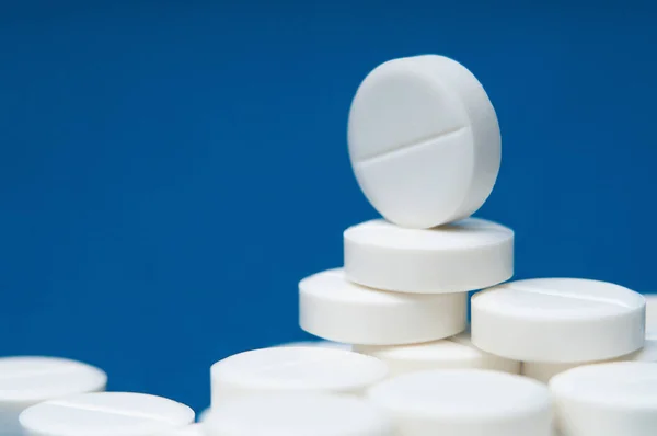 Hastalık tedavisi için mavi arka planda bir sürü hap var.