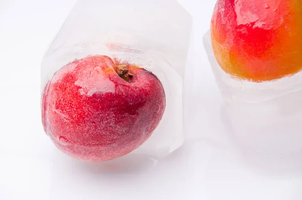 Beyaz arka planda buzda donmuş meyve nektarları