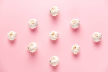 Keskin ve nazik sarımsak deseni üstünde pembe bir arka planda