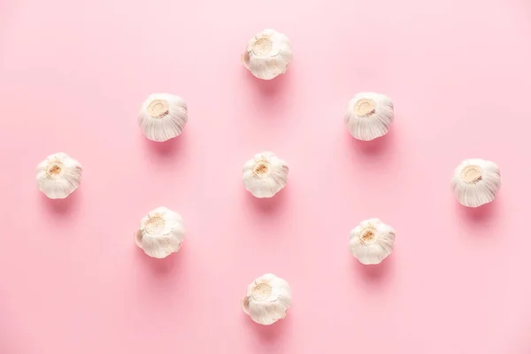 Keskin ve nazik sarımsak deseni üstünde pembe bir arka planda