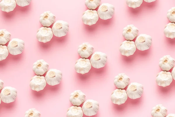 Keskin ve nazik sarımsak deseni üstünde pembe bir arka planda