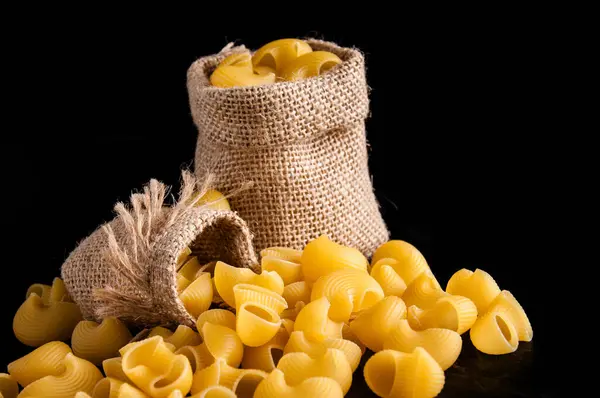 Makarnanın siyah arka plandaki deposu.