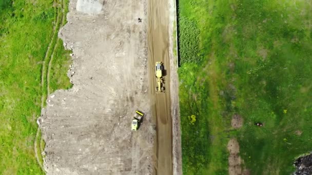 道路を建設するプロセス トラクターは地面を整列させます 高さから道路の建設 機械の動き 建設道路の空中風景 — ストック動画