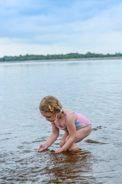 Kız yazın gölde yüzmekten hoşlanır. Suya su sıçratmayı çok seviyor..