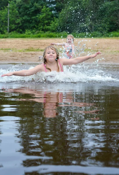 The girl enjoys swimming on the lake in summer. She really likes to splash in the water.