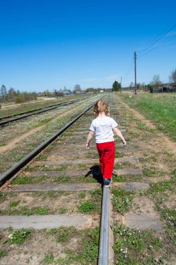 Bir kız raylarda yürüyor. Demiryolu.. 