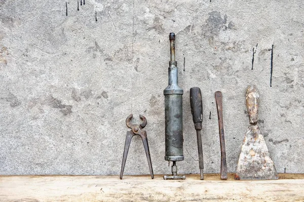 老墙前木板上的旧工具 — 图库照片