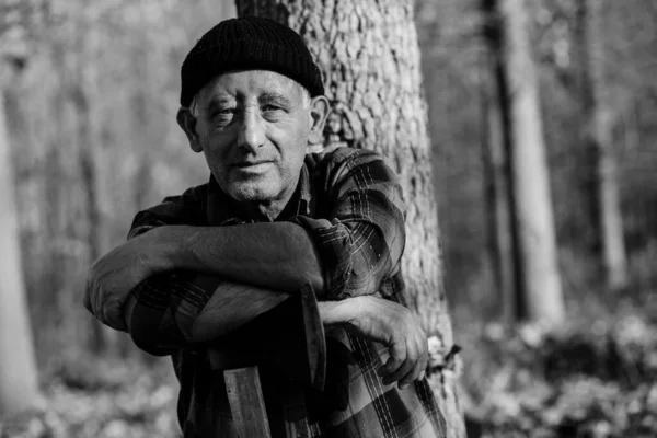 Old man with an ax in forest