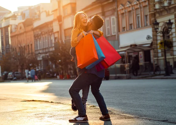 Young couple walking in city with shopping bags