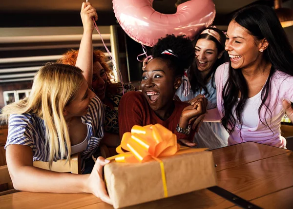 Group of girls surprise their girlfriend with a birthday party at a coffee shop.