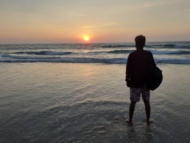  A man watching beautiful sunset at Bagha Beach, Goa, India