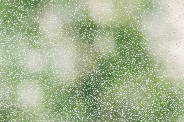 Капли дождя на поверхности оконных стекол с облачным фоном. Капли дождя, изолированные на облачном фоне. — стоковое фото