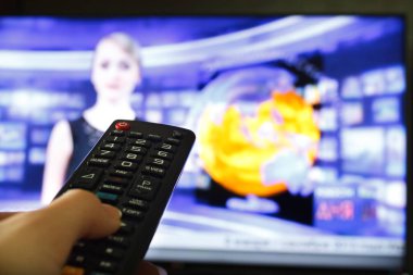 Tv uzaktan kumanda bir televizyon ile arka planda tutan el kadar kapatın.