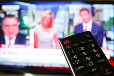 Tv uzaktan kumanda bir televizyon ile arka planda tutan el kadar kapatın.