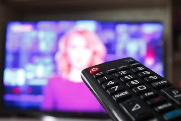 Tv uzaktan kumanda bir televizyon ile arka planda tutan el kadar kapatın.