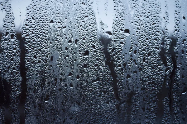 Rain drops on window glasses surface with sky cloudy background — Stock Photo, Image