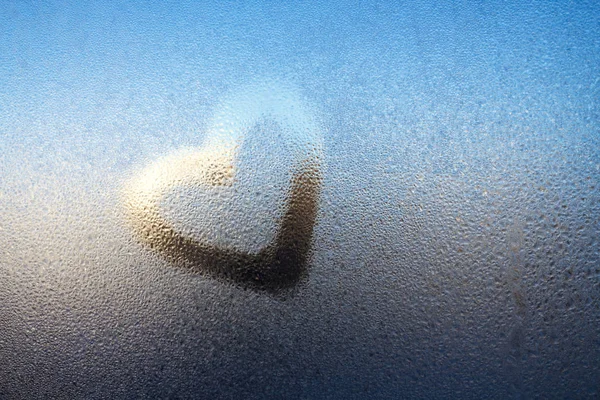 Zeichnen Sie ein Herz auf den Spiegel mit Wassertropfen und verwenden Sie ein Hintergrundbild, um die Liebe zu zeigen. — Stockfoto