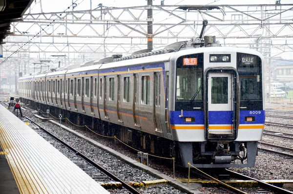 Поезда останавливаются на железнодорожной станции Вакаяма во время дождя — стоковое фото