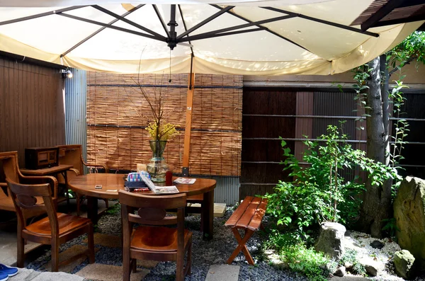 Декоративная современная деревянная мебель и зонтик в саду — стоковое фото