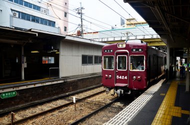 Kyoto meydanının çalışan Hankyu kyoto satırının kırmızı klasik tren