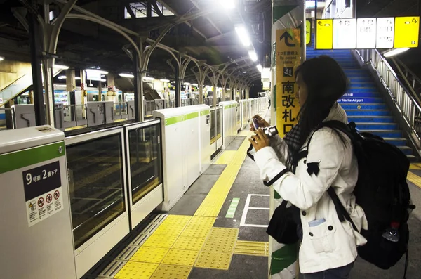 Путешественница тайская женщина ждать поезд JR yamanote линии железнодорожного поезда — стоковое фото