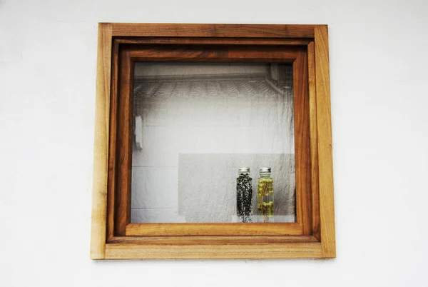 Fleurs et plantes dans les deux bouteilles sur la fenêtre de la boîte en bois — Photo