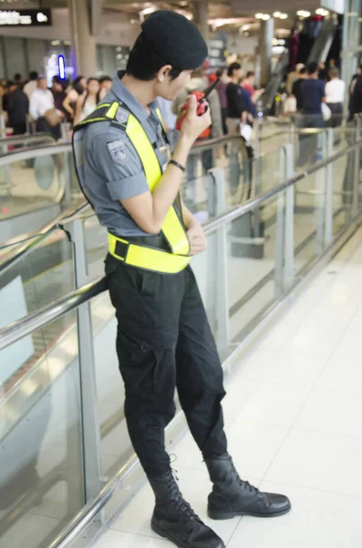Размытое движение охранника тайского аэропорта стоя и используя w — стоковое фото
