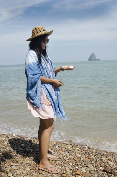 Азіатський тайського жінка позують з тримати рок і seashell з боку на с — стокове фото