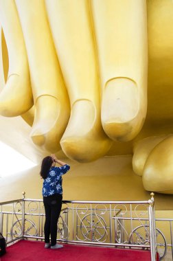 Aşağı işaret eden Asya Tayland yaşlı kadın dua ve dokunmatik parmak 