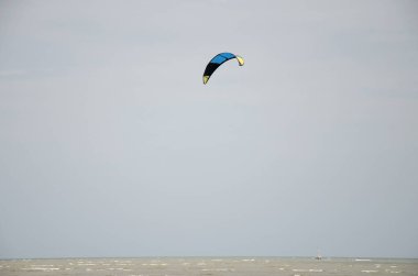 Tay insanlar iskambil uçurtma sörf ile rüzgar ve dalga denizde 