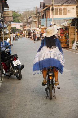 Asya Taylandlı kadın binmek bisiklet ve yabancı yolcuları shopp yürümek