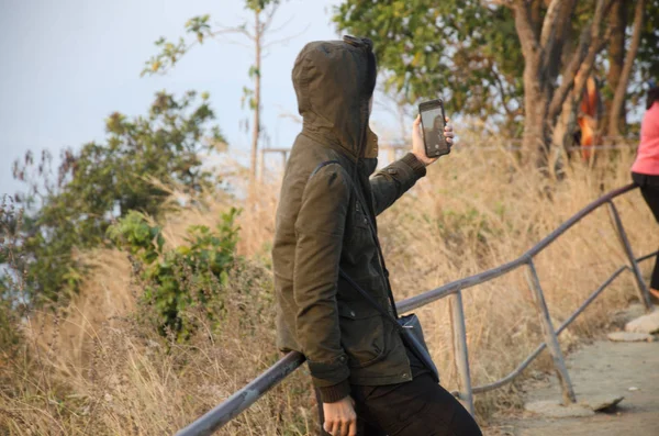 Тайцы, позирующие и пользующиеся смартфонами, делают селфи на смотровой площадке — стоковое фото