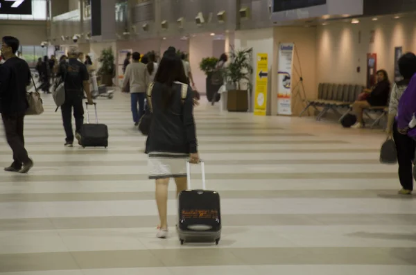 Matkustaja ja matkustaja ihmiset vetää matkatavarat ja odota vastaan matkatavarat — kuvapankkivalokuva