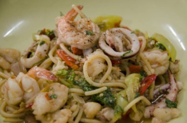 Spagetti kızarmış biber ile baharatlı karışık deniz ürünleri ve fesleğen yaprağı