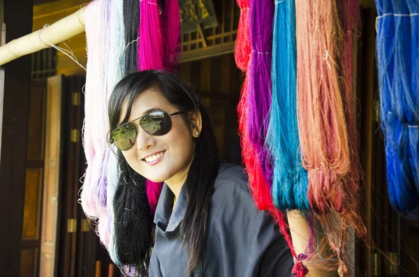 Asiática tailandesa mujer viaje y posando con colorido hilo de seda —  Fotos de Stock