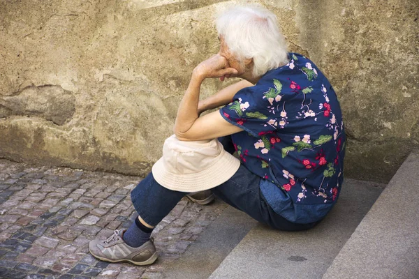 Czechia old women sitting lonely at pathway of Prague castle — Stock Photo, Image