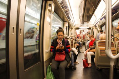 Metro f içinde oturan insanlar ve yabancı yolcuları Fransız
