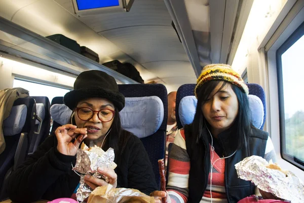 Asain women mother and daughter eating snack and listen music on — Stock Photo, Image