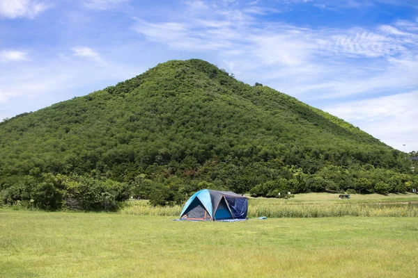 Travelers people build tent camping on grass field for rest and