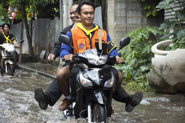 Motocicleta Taxis y voluntarios que llevan personas pasaron la inundación en el camino van al templo de Bang pai — Foto de Stock