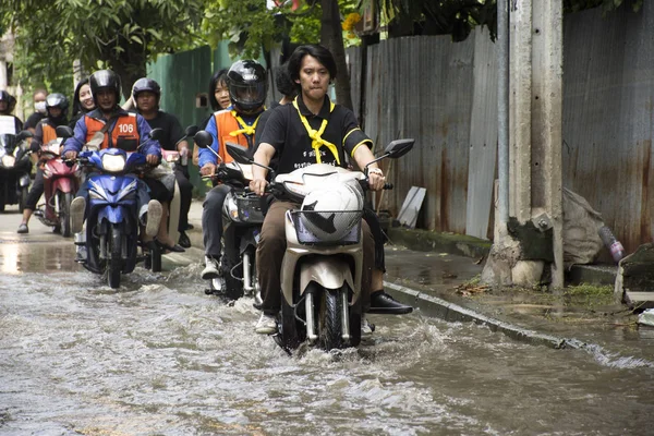 Motocicleta Taxis y voluntarios que llevan personas pasaron la inundación en el camino van al templo de Bang pai — Foto de Stock