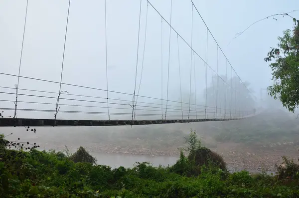 Thai persone che trasportano legna da ardere a piedi su ponte di legno Sospensione — Foto Stock