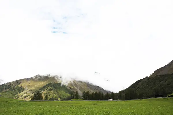 道路の横にある山や草のフィールドの風景を表示します。 — ストック写真