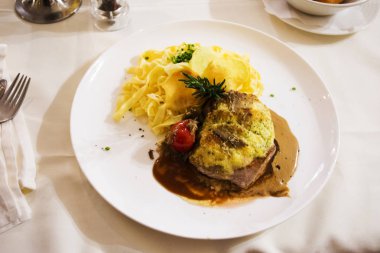 Izgara domuz eti ve et suyu sosu ve makarna mantar krema cer üzerinde